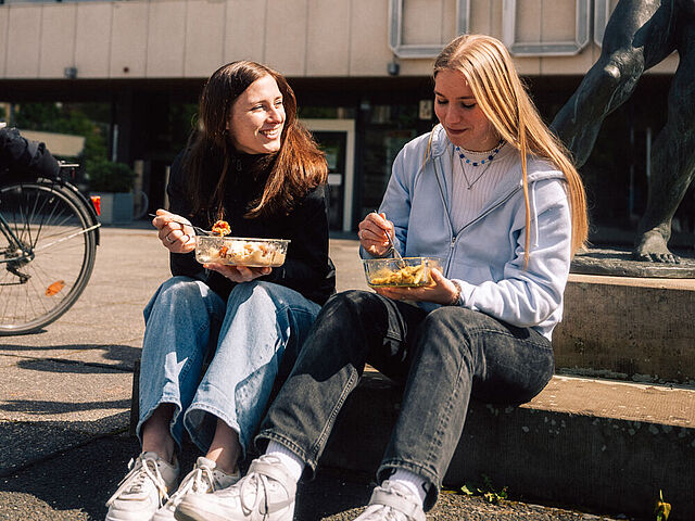 Studierende der TU Braunschweig beim Essen vor dem Forumsgebäude