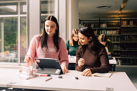 Zwei Studentinnen lernen gemeinsam am Tablet 