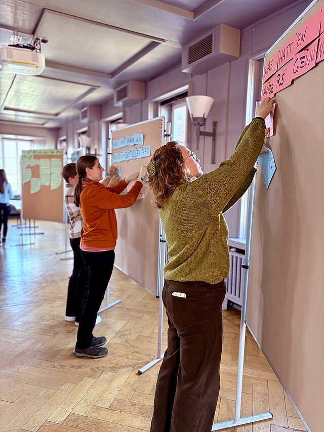 Studierende an Pinnwand