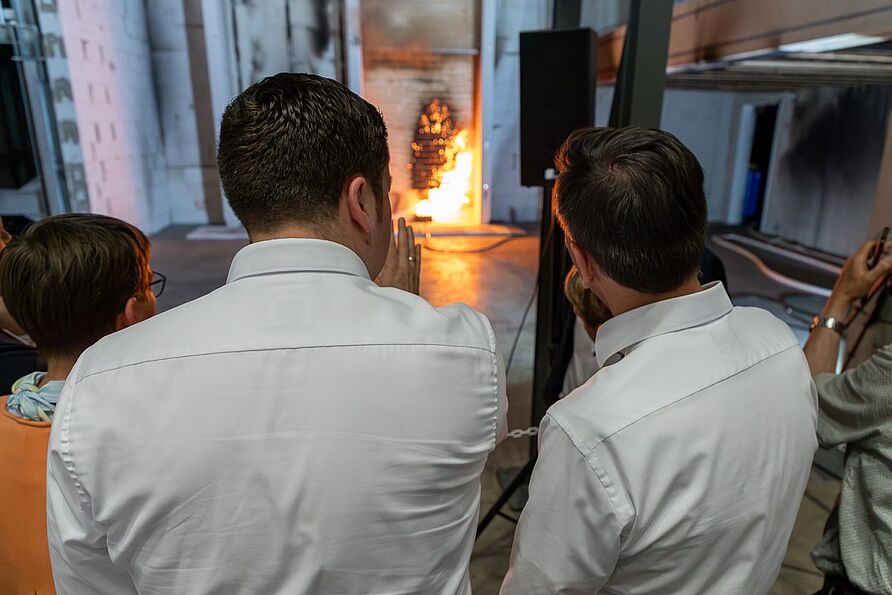 Für den Versuch wurde eine mehrgeschossige Holzfassade entzündet. Die Wissenschaftler*innen zeigten die Wirkung sogenannter Brandsperren. Auf diese Weise lässt sich die Brandausbreitung im Fassadenbereich wirksam begrenzen.