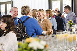 Gäste unterhalten sich fröhlich bei der Feier zum 50-jährigen Jubiläum des Sprachenzentrums miteinander.