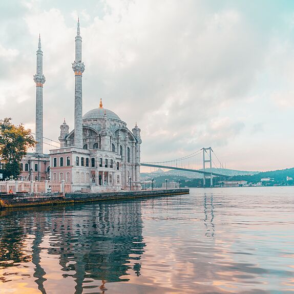 Der Blick vom Wasser auf die Bosporus Brücke und eine Moschee in Istanbul.