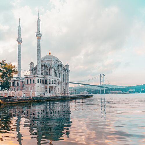 Der Blick vom Wasser auf die Bosporus Brücke und eine Moschee in Istanbul.