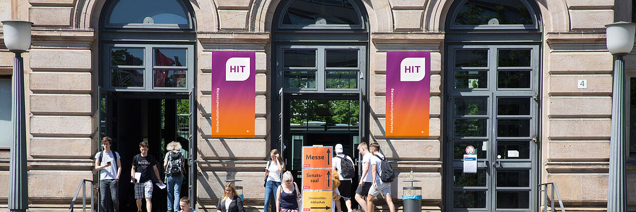 Menschen vor dem Altgebäude auf dem TU Campus beim Hochschulinformationstag 