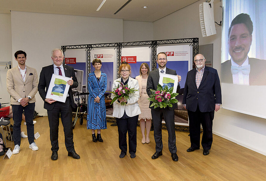 (von links) Dr.-Ing. Adrian Sonka (Geschäftsführer NFF), Prof. Dr.-Ing. Arno Kwade (Laudator und Doktorvater von Dr. Linus Froböse, Institut für Partikeltechnik), TU-Präsidentin Prof. Dr. Angela Ittel, Ulrike Hanshold-Kunerth (Stifterin Doktorandenpreis), Dr. Kerstin Schmidt (Laudatorin in Vertretung von Prof. Spengler, akademi-sche Rätin am Institut für Automobilwirtschaft und indust-rielle Produktion), Dr. Christian Thies (Preisträger), Dr.-Ing. Volker Hanshold (Stifter Doktorandenpreis) und auf der Leinwand Dr.-Ing. Linus Froböse (Preisträger). 