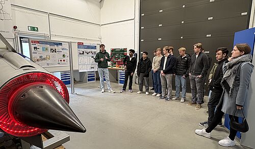 Die Schüler der schwedischen Delegation vor einem Triebwerk