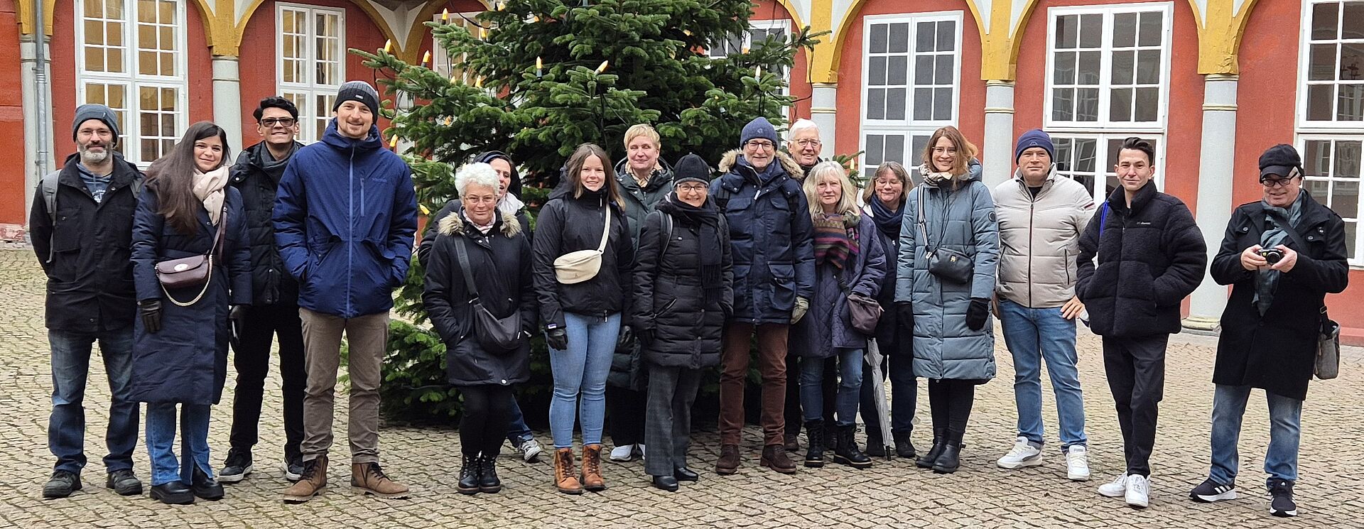 Mitarbeitende des ISBS im Schloss Wolfenbüttel vor einem Weihnachtsbaum