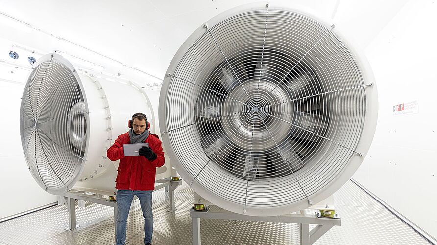 Eröffnung des Klimarollenprüfstand am NFF: Mitarbeiter steht vor einer großen Turbine