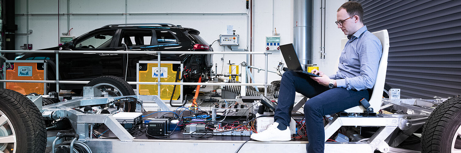 Mitarbeiter sitz auf einer beweglichen Forschungsplattform mit Laptop. 