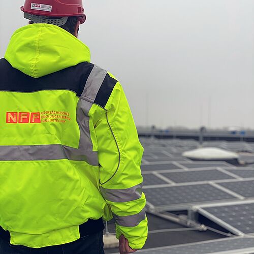Geheime Orte: Bauarbeiter besichtigt Photovoltaikanlage auf dem NFF-Dach. 