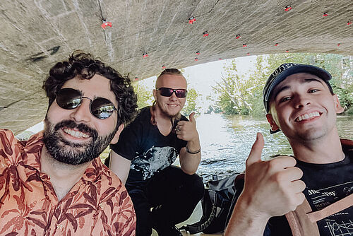 3 Teilnehmer der Summer School machen ein Selfie während sie in einem Boot auf der Oker paddeln.