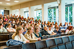 Studieninteressierte sitzen in einem Hörsaal und hören eine Vorlesung