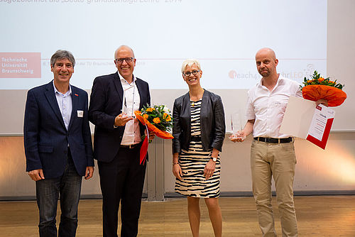 Lehrende mit Präsidentin und Vizepräsident auf der Bühne