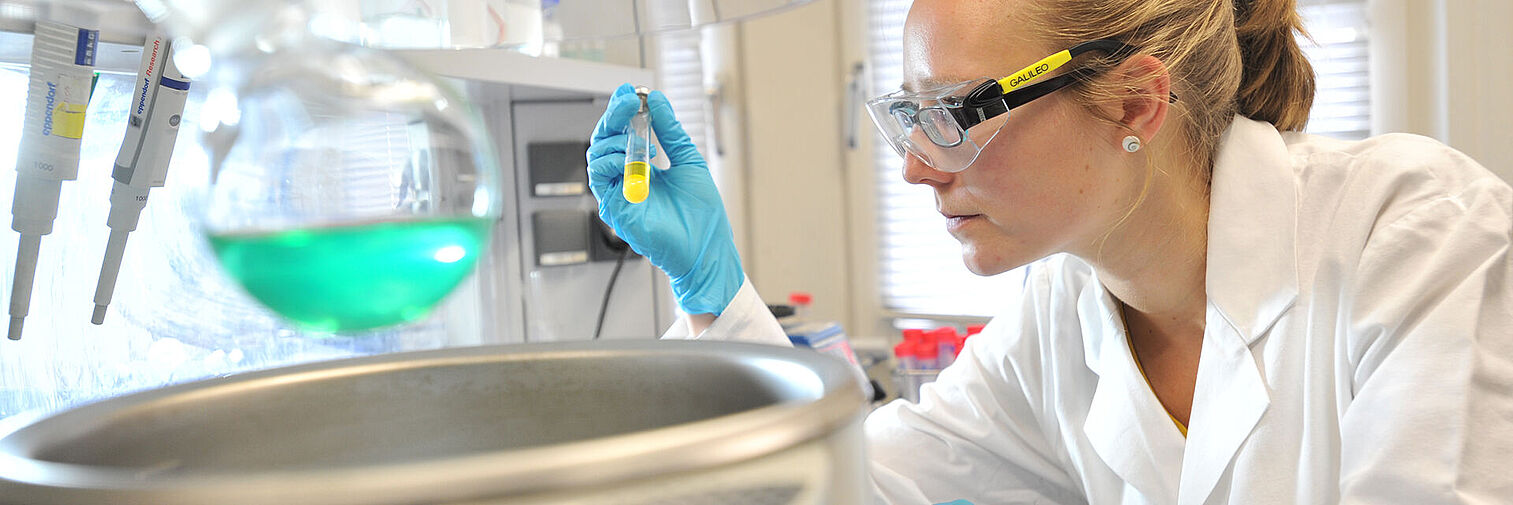 Eine Forscherin nimmt eine Probe in einem Chemielabor 