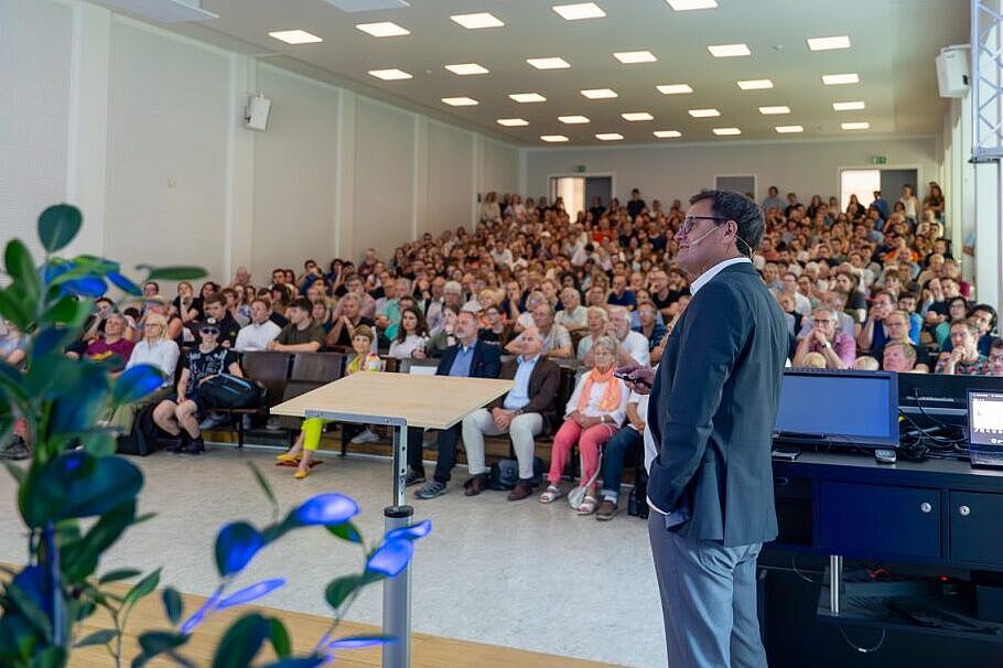 Zu sehen ist der Referent Professor Markus Rex vor einem gefüllten Hörsaal.