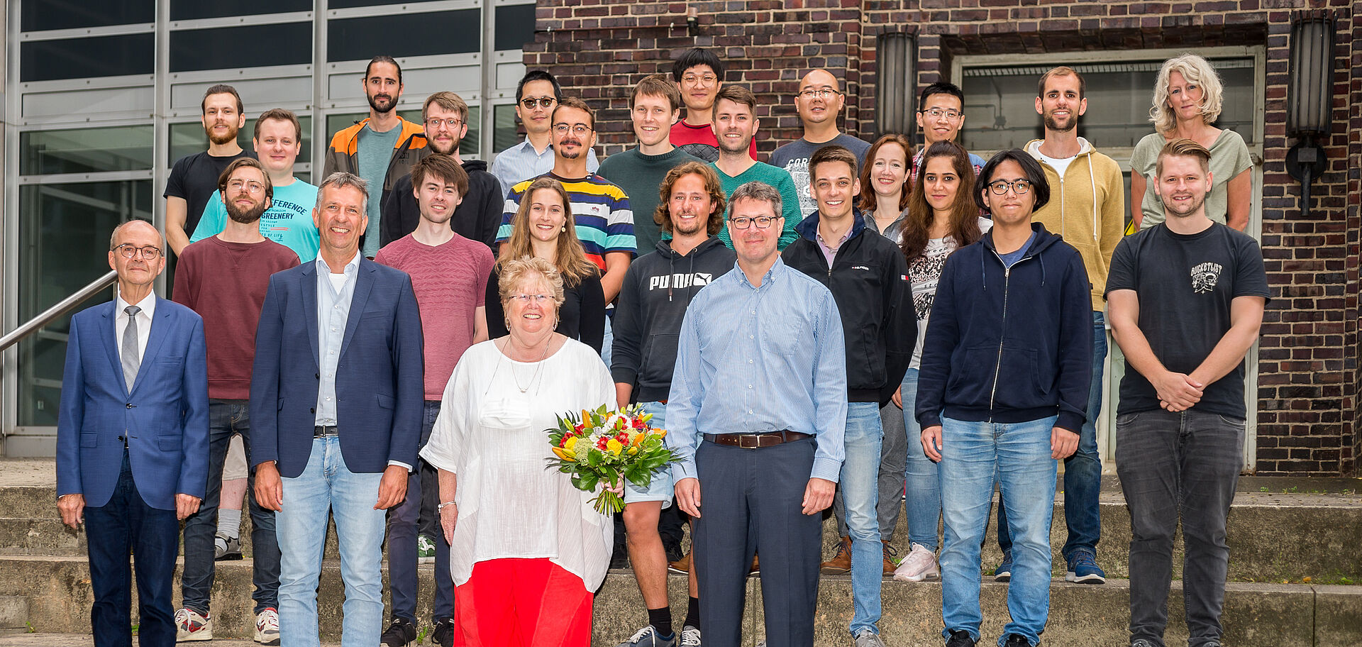 Gruppenfoto Kollegen um Frau Erichsen-Rua mit Blumenstrauss