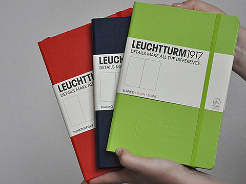 Notizbücher in rot, grün und blau mit Logo der TU Braunschweig