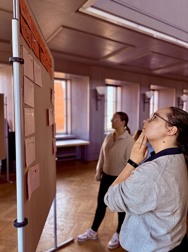 Studierende an Pinnwand