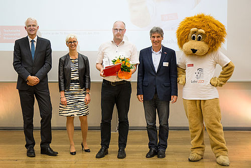 Lehrende mit Präsidentin und Vizepräsident auf der Bühne