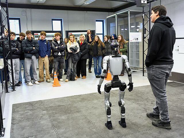 Schülerinnen und Schüler beobachten Humanoiden auf Testfeld