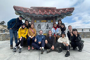 Eine Gruppe von Studierenden posiert vor einem typisch taiwanesischen Gebäude.