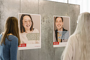 Gäste schauen sich die Posterausstellung bei der Jubiläumsfeier des Sprachenzentrums an. 