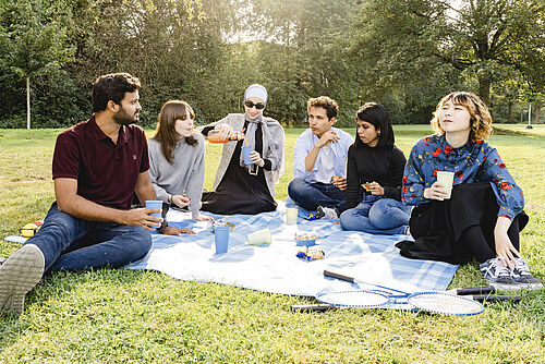 Studierende essen gemeinsam im Park.