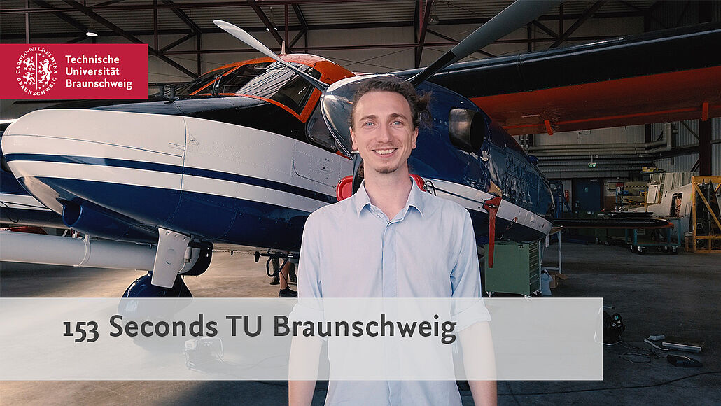 Student stands in front of research aircraft