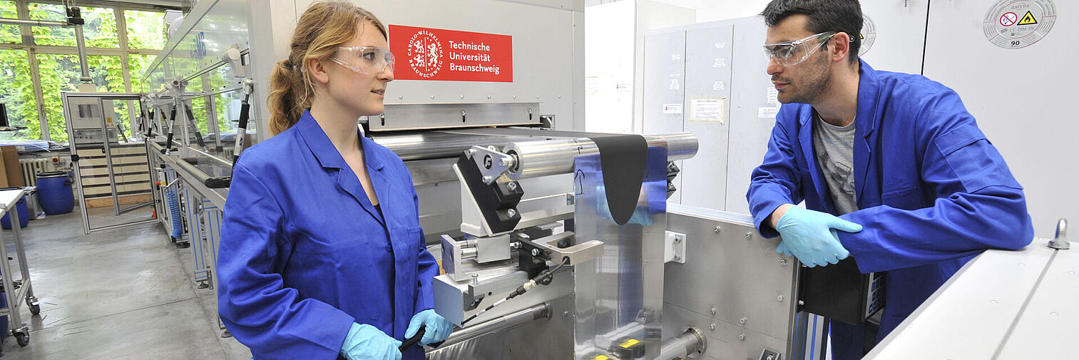 Werkstatt, 2 Menschen in Arbeitskleidung 