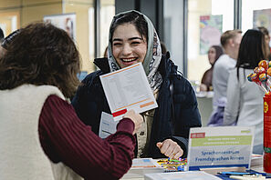 Eine Studentin lässt sich an einem Infotisch beim Kick-Off der Welcome Week beraten.