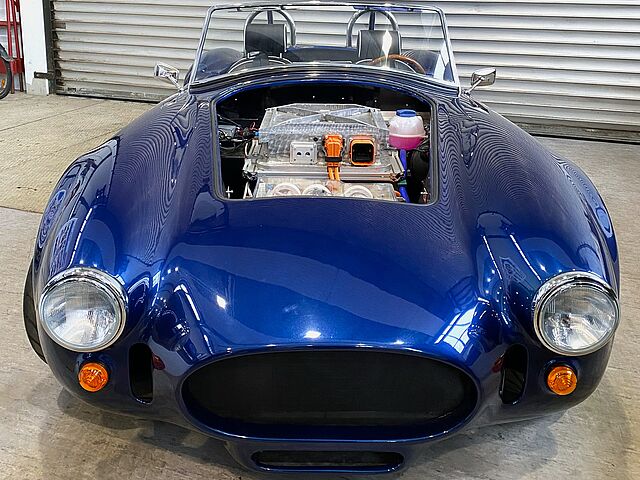 Ein blaues E-Auto mit offenem Motorraum