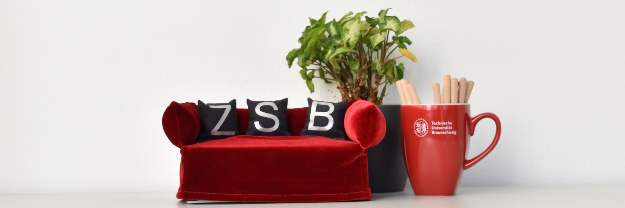 Rotes Miniatursofa mit Palme und Tasse 