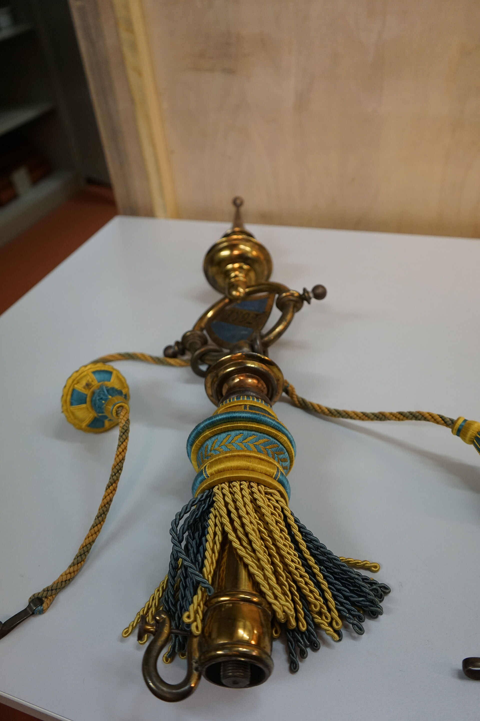 Top of the pole used to hold the traditional banner from 1892. It is elaborately decorated with blue/yellow ornaments and the year 1892.