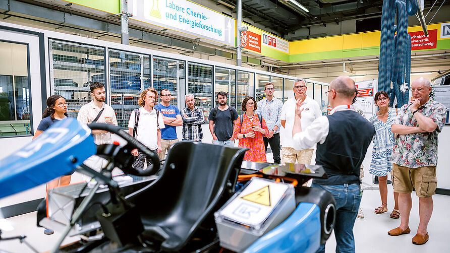 CampusXperience im NFF-Technikum: Wissenschaftlicher Mitarbeiter erläutert ein Forschungsprojekt einer Besuchergruppe 