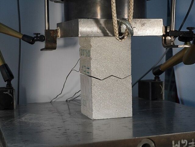 C05 examines the potentials and challenges of robotic manufacturing techniques for proposing and evaluating structural connections applied to precast, additively manufactured concrete elements. Considering the characteristics of different AM processes, such as particle-bed, extrusion and shotcrete, and the capabilities of various subtractive post-processing techniques, including milling and sawing, the project addresses a broad range of parameters influencing joint performance. The work focuses on defining, assessing and comparing different types of dry concrete joints, analysing the tangential behaviour of milled and/or printed specimens (including the effects of surface smoothness), and evaluating the structural performance of subtractive versus directly printed interfaces. The investigation strategy combines experimental, numerical and theoretical studies at both micro- and meso-scale, under compression, shear and combined loading. These outcomes aim to provide fundamental insight into the load-bearing behaviour of AM dry joints. The project follows four consecutive work packages (WP). WP1 identifies and selects suitable joint geometries using a comprehensive catalogue derived from timber, steel, concrete and bionic concepts. Evaluation criteria, weighting factors and an algorithm support the selection of four joint profiles. WP2 and WP3 investigate the structural performance numerically and experimentally using specimens produced by all targeted AM processes and post-processed through subtractive manufacturing. Laser scans validate the accuracy of the CNC-produced joint geometries and support the refinement of the manufacturing approach. WP4 integrates the results to design, simulate and test a demonstrator composed of 3D-printed elements connected through dry joints. Finally, all numerical, experimental and post-processing data are combined to establish a calculation approach for AM dry joints, calibrated using large-scale demonstrator tests with pre-stressed interfaces.