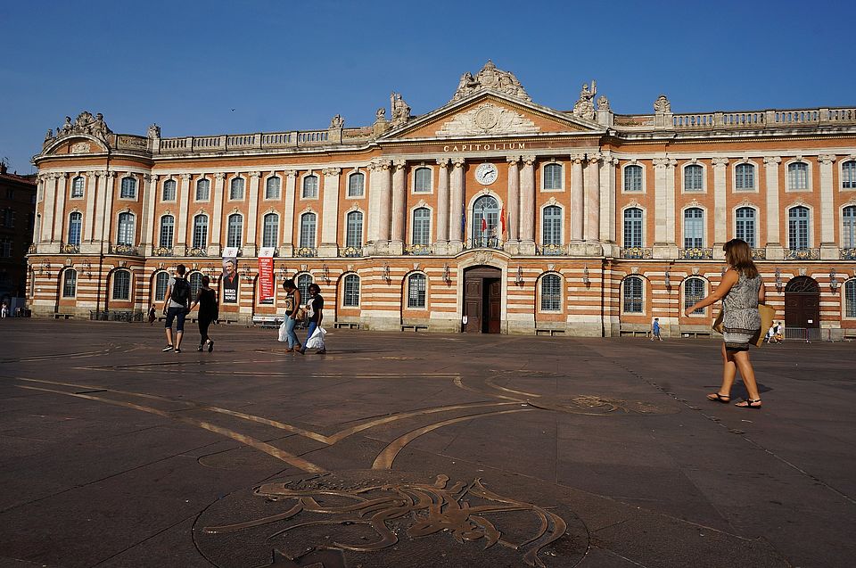 Man sieht den Platz vor dem Toulouse Place Parlament, den einige Menschen überqueren.