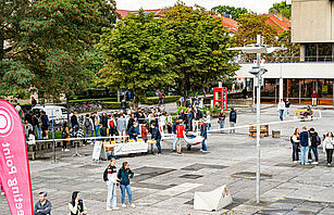 Studieninteressierte stehen auf dem Universitätsplatz