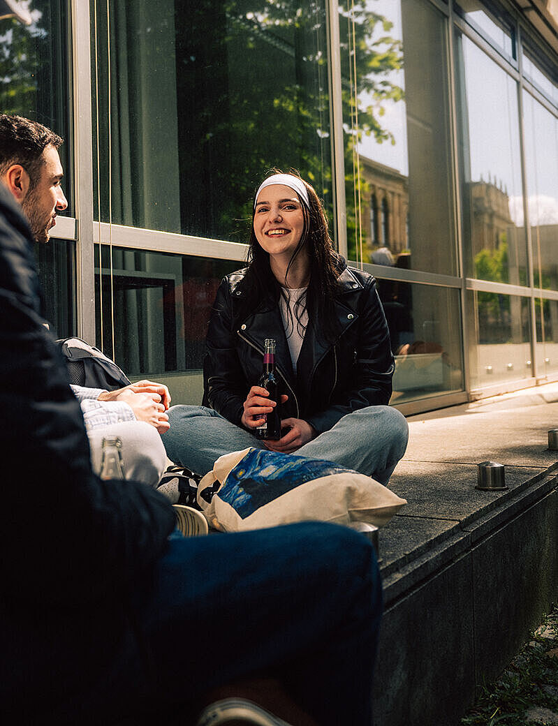 Laura mit ihren Freund*innen am Studierendenhaus.