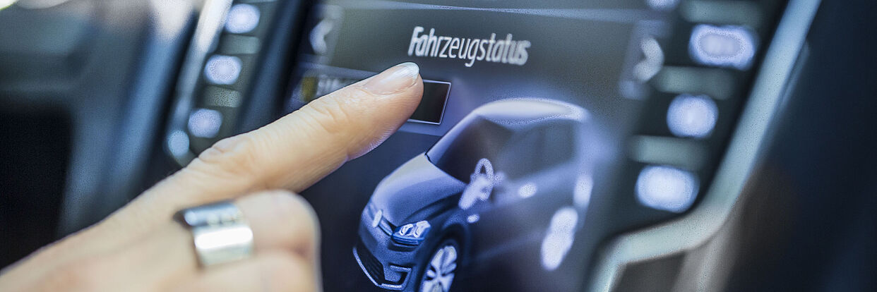 Finger auf Display im Auto 