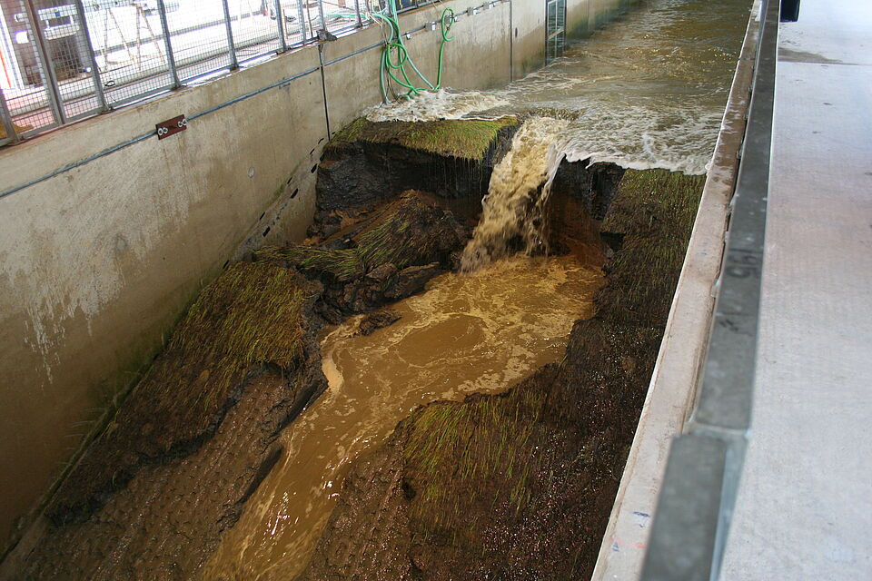 Wellenüberlauf mit Deichbruch an einem Grasdeich