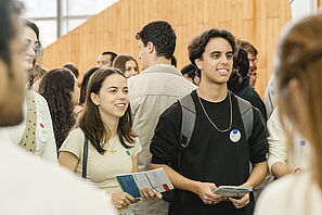 Students are standing in the main lecture hall of TU Braunschweig and chatting.