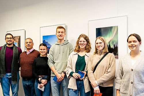 The five winners stand in front of the winning pictures with representatives of the jury.