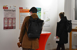 Menschen betrachten Poster bei der Impact Week