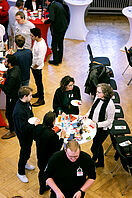 Conference participants stand in the auditorium of the Haus der Wissenschaft and chat.