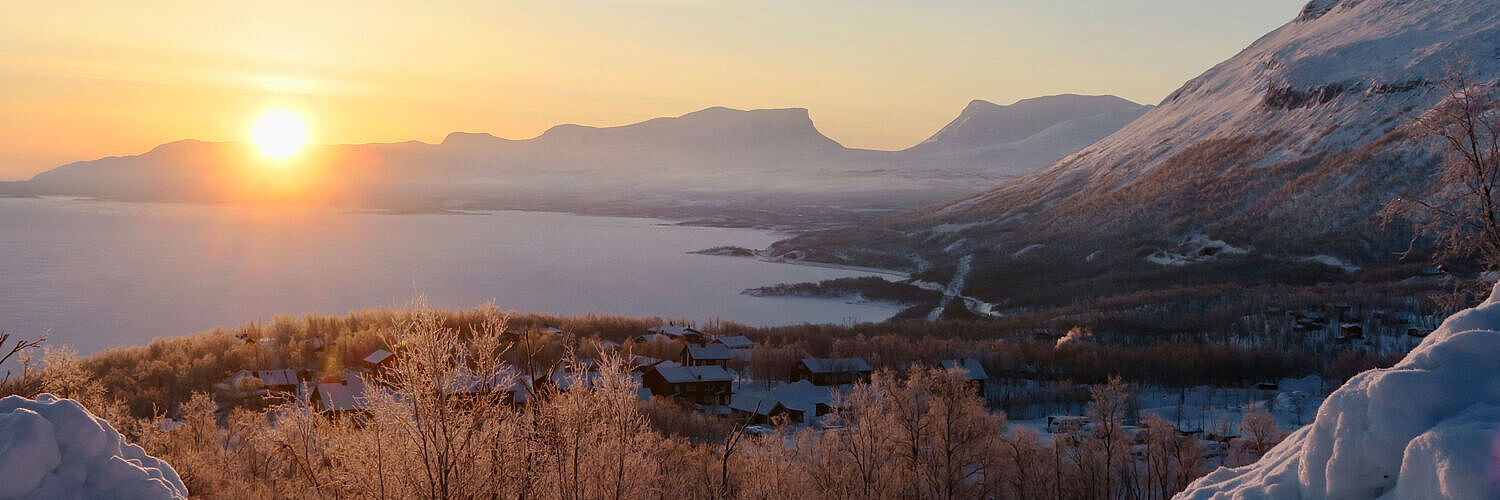 Sonnenaufgang über einem See im winterlichen Schweden. 