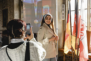 Eine Studentin lässt sich beim offiziellen Empfang der Stadt Braunschweig von einer Freundin fotografieren.