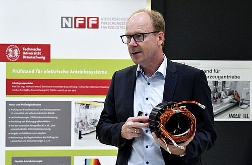 Prof. Henke mit einer Batteriespule in der Hand