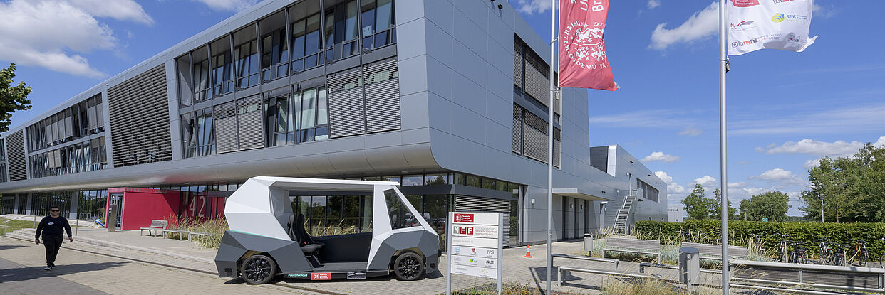 Forschungsfahrzeug RAION vor dem NFF-Gebäude an einem sommerlichen Tag 