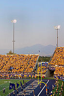 Ein belebter Blick aus dem Inneren eines American-Football-Stadions mit einem Bergpanorama im Hintergrund.