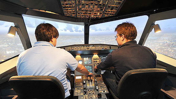 Zwei Männer sitzen im Flugsimulator